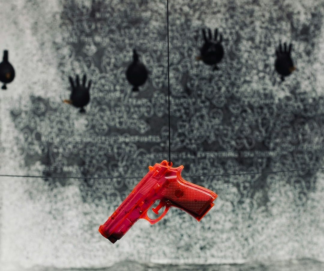 A red plastic gun hanging in front of a target