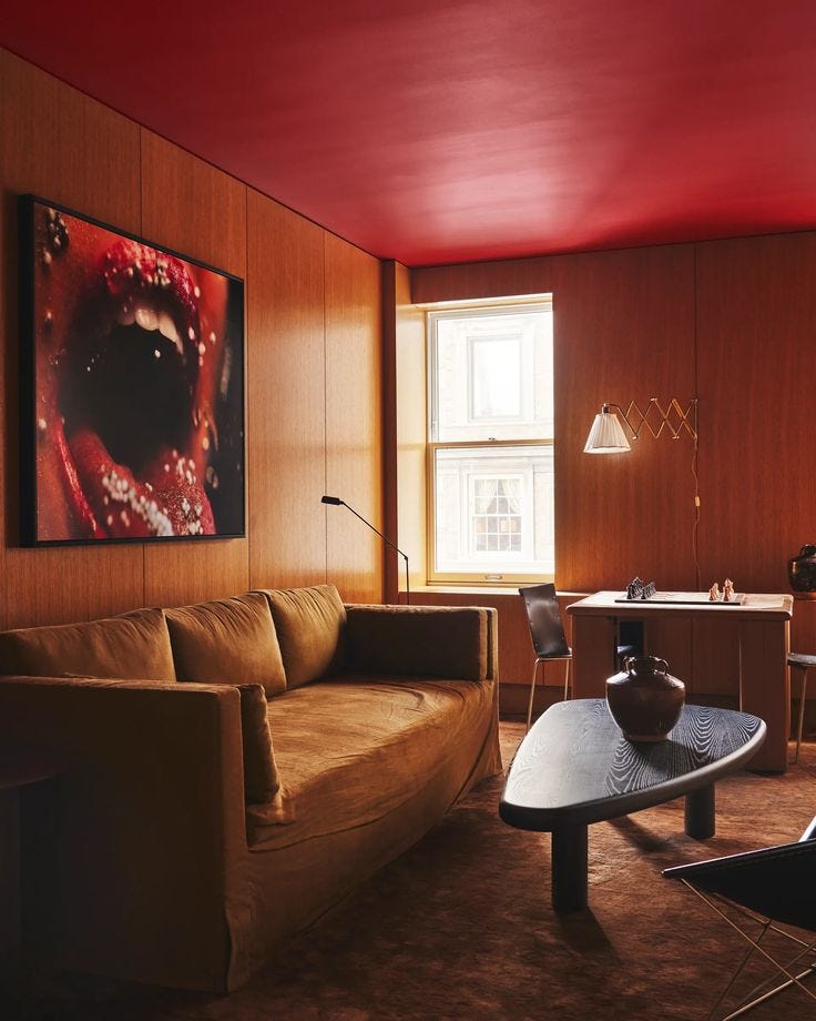 This may contain: a living room filled with furniture and a painting on the wall