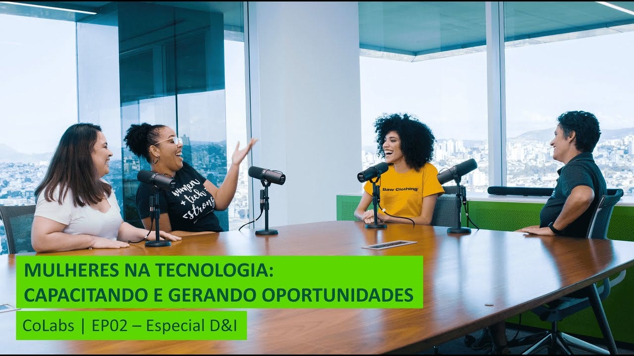 Quatro mulheres sentadas ao redor de uma mesa, com microfones, conversando e sorrindo