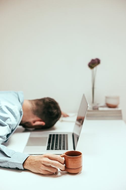 Free An Overworked Man Holding a Cup Stock Photo