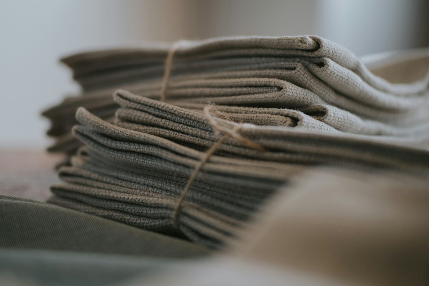 Stacks of folded linen textiles showing the natural texture, softness, and craftsmanship of the material. Stacks of folded linen textiles showing the natural texture, softness, and craftsmanship of the material.