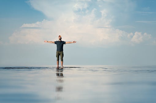 A Man Stands In Shallow Water His Hands Are Raised Stock Photo - Download  Image Now - iStock