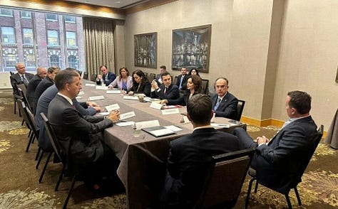 Foto 1. Grenell është fotografuar nga pas, por asnjë tabelë me emër nuk është e dukshme. Foto 2. Ministri i jashtëm i Serbisë Marko Djuric qëndron pas Eliza Spiropalit, Ministres së Jashtme të Shqipërisë ndërsa Grenell duket përball saj. Gjuha e trupit lexohet si një prezantim i ndërmjetësuar nga Beogradi, jo nga ndonjë zyrtar amerikan. Foto 3. Richard Grenell i ulur në tryezë përball pjesëmarrësve të tjerë, dhe nuk ka asnjë tabelë që thotë “United States” përpara tij dhe Presidentja Osmani shihet në tryezë e katërta nga e djathta.