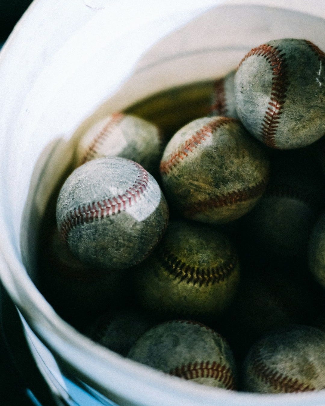 a bucket filled with baseballs sitting on top of a table a bucket filled with baseballs sitting on top of a table