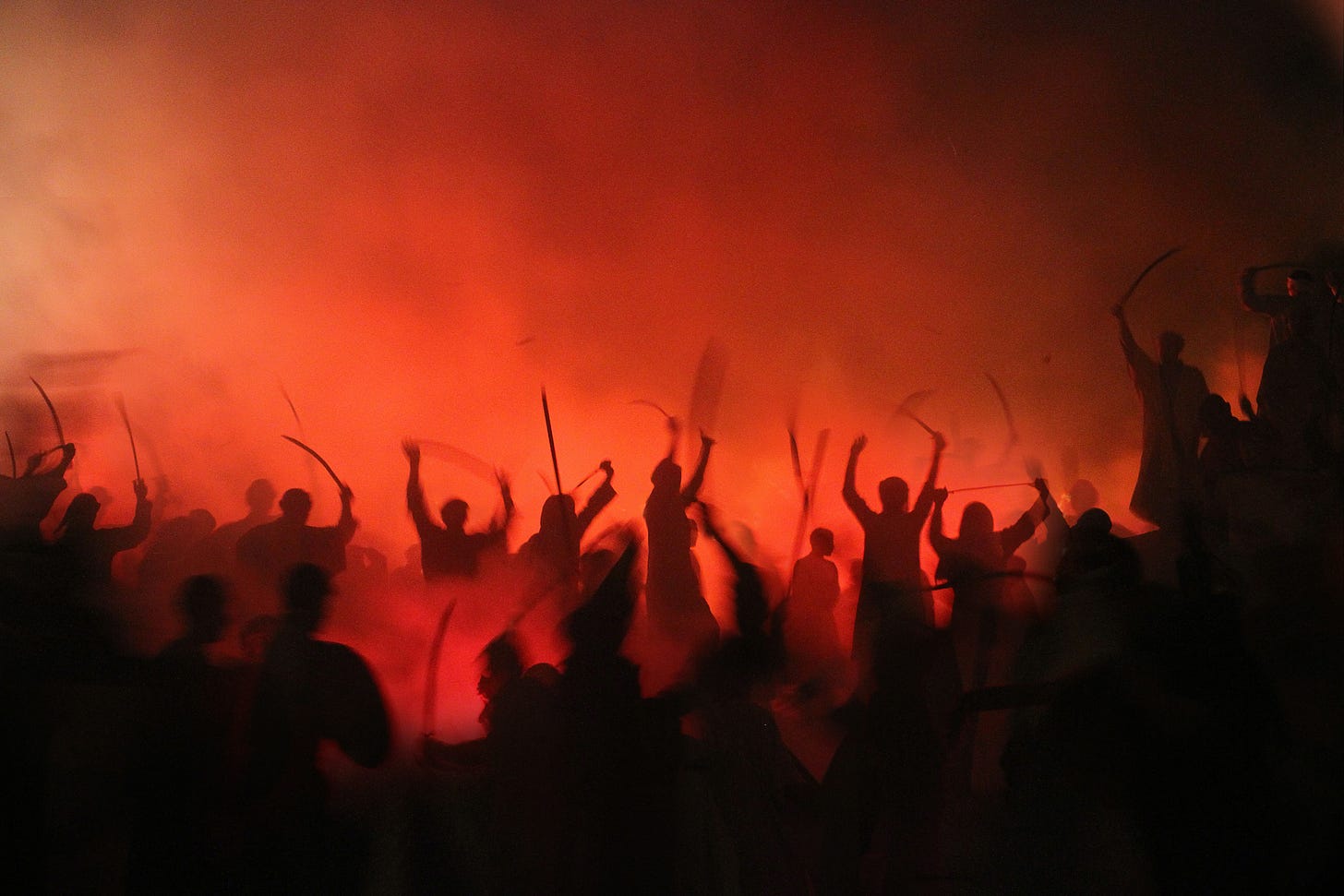 Silhouette of people fighting with weapons in a red haze Silhouette of people fighting with weapons in a red haze
