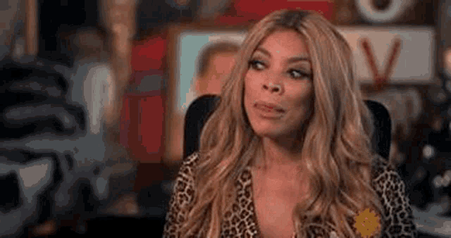 wendy williams is sitting in a chair wearing a leopard print shirt . wendy williams is sitting in a chair wearing a leopard print shirt .