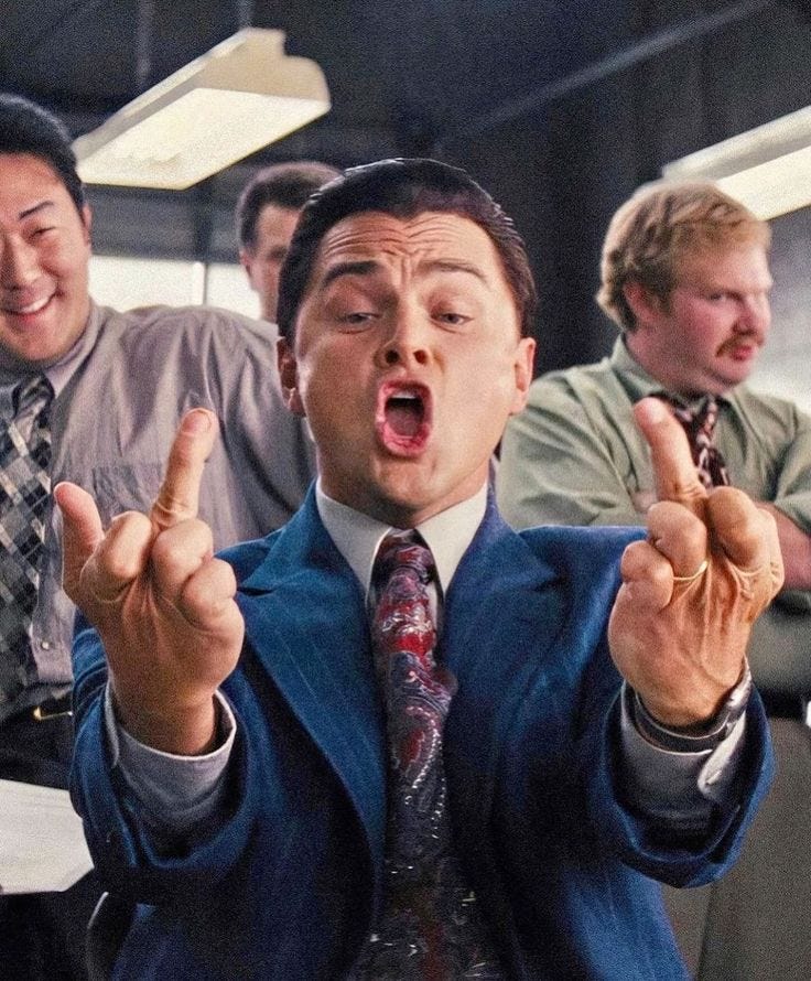 This may contain: a man in a suit and tie making the vulcan sign with his hands while others look on This may contain: a man in a suit and tie making the vulcan sign with his hands while others look on