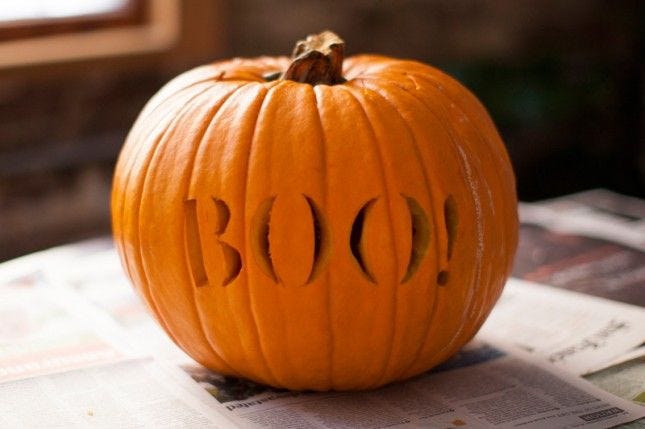 This may contain: a carved pumpkin sitting on top of a newspaper