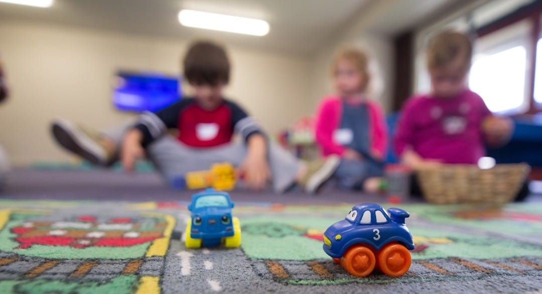 a group of children playing with toys on the floor
