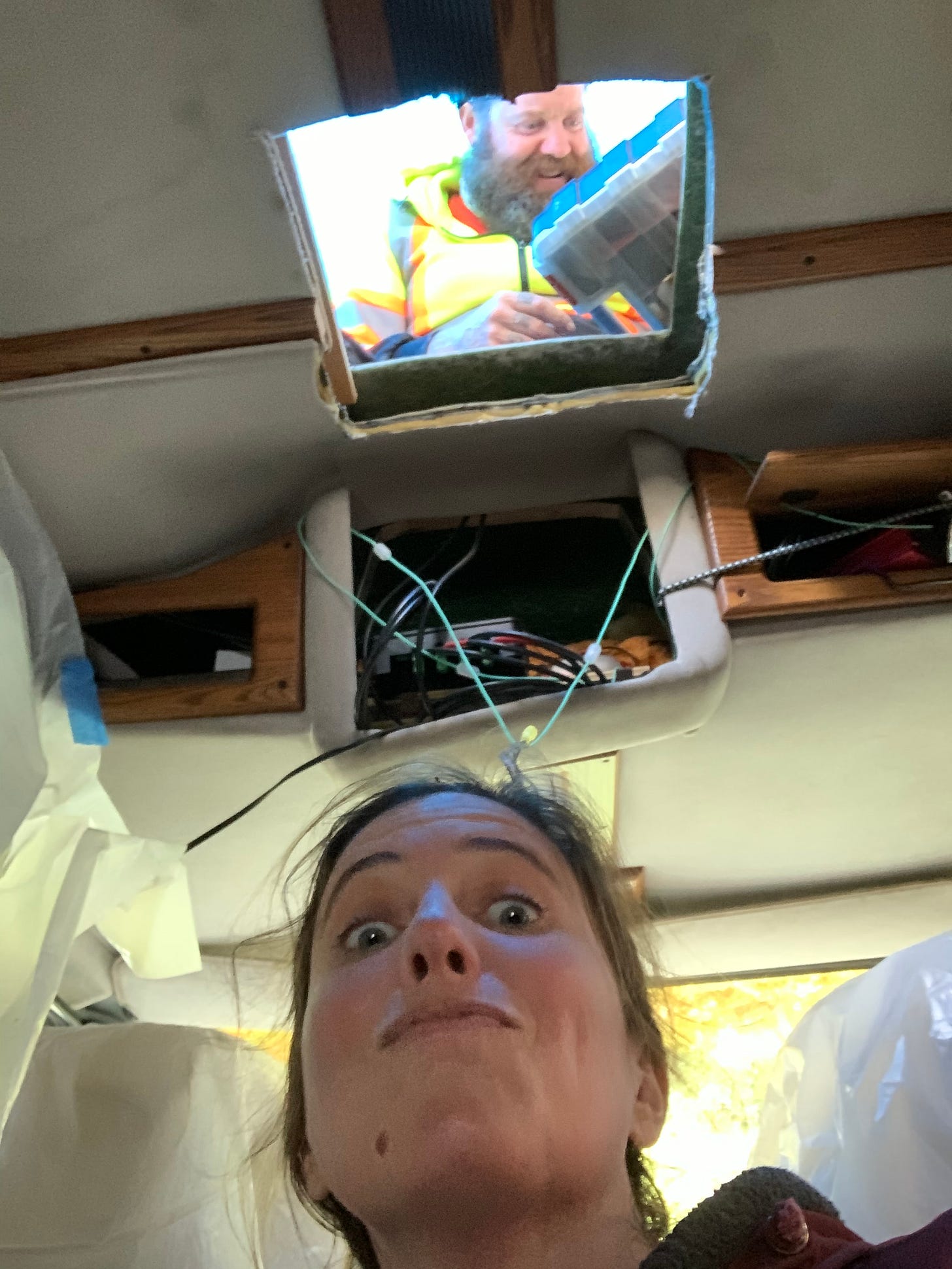 A photo of a woman, the author, inside a van below a square whole in the roof, through which you can see a man with a saw A photo of a woman, the author, inside a van below a square whole in the roof, through which you can see a man with a saw