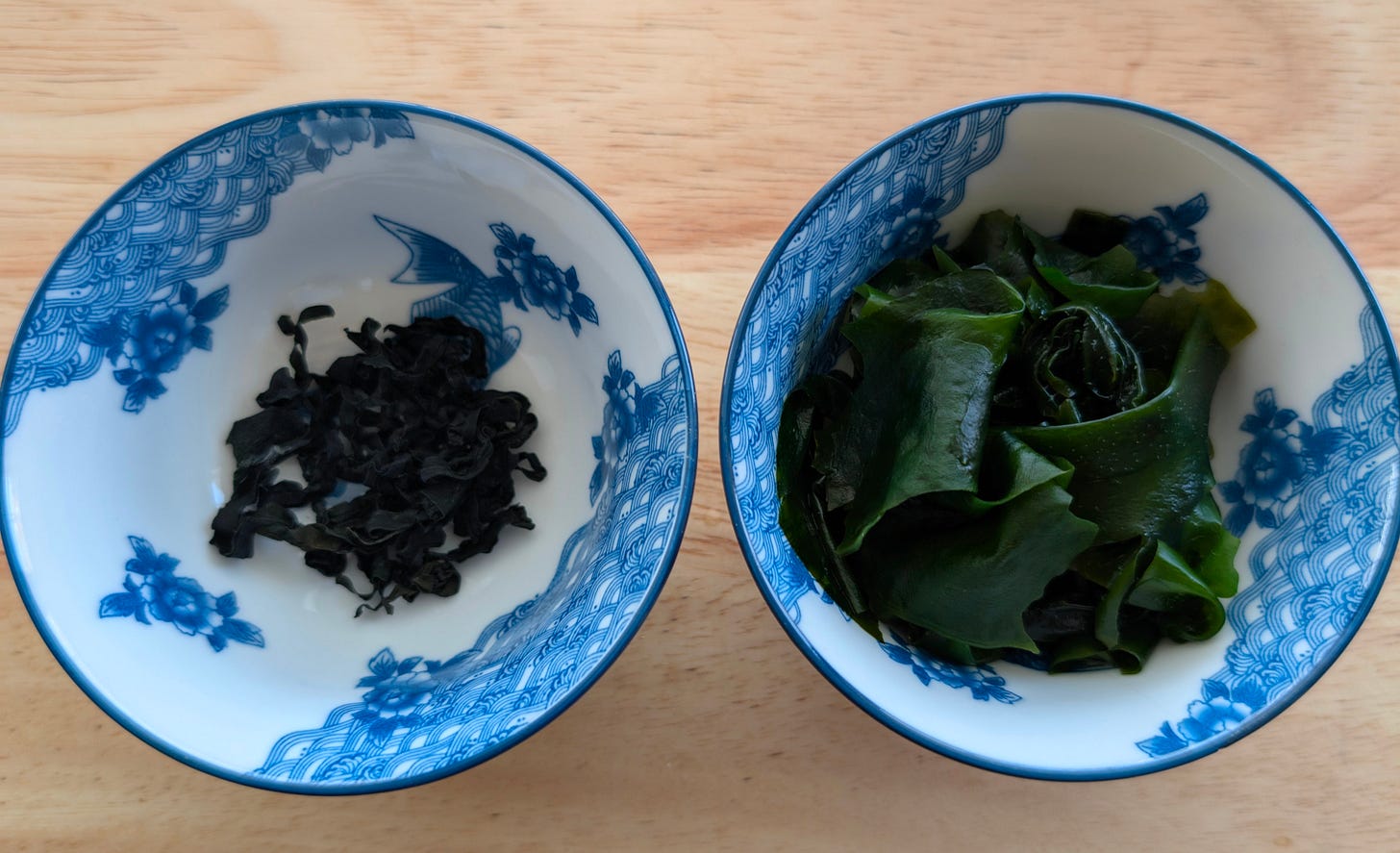Side-by-side comparison of dried wakame and rehydrated wakame in small bowls, showing the texture and size difference. Side-by-side comparison of dried wakame and rehydrated wakame in small bowls, showing the texture and size difference.