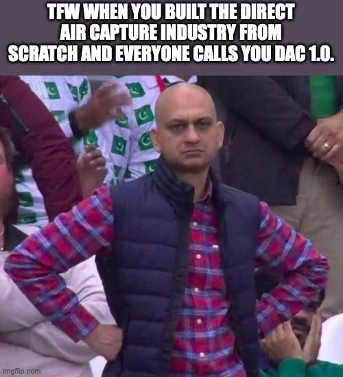 Caption: "TFW WHEN YOU BUILT THE DIRECT AIR CAPTURE INDUSTRY FROM SCRATCH AND EVERYONE CALLS YOU DAC 1.0." Below, the disappointed Pakistani cricket fan in a navy vest and plaid shirt stands with hands on hips in a crowd.