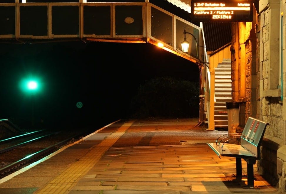 a bench sitting on the side of a train track