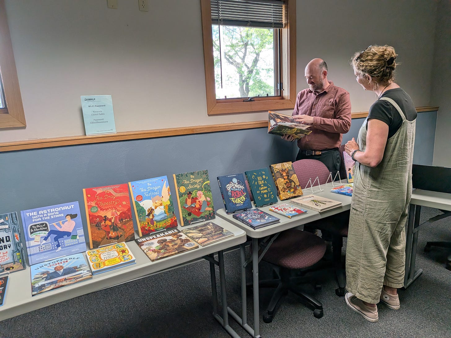 Image: A bookseller recommending a picture book to a library media specialist Image: A bookseller recommending a picture book to a library media specialist