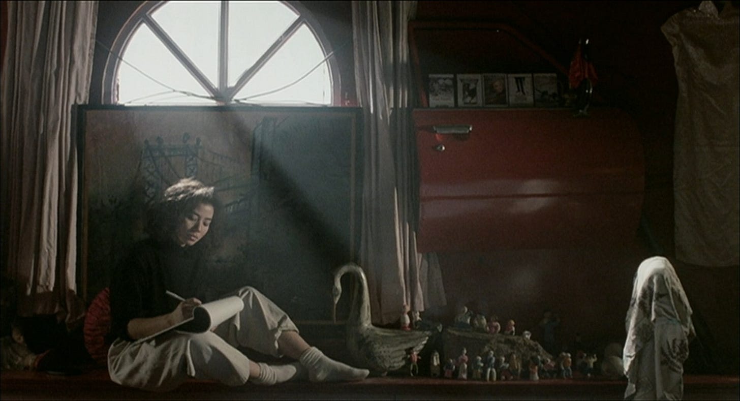 Cherie Chung sketches on a pad of paper under a sunlit window in "An Autumn's Tale" (1987)