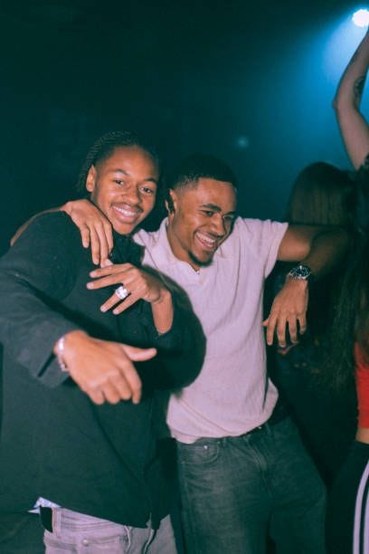 portrait of cheerful young man dancing with male friend at nightclub - guys at a nightclub stock pictures, royalty-free photos & images