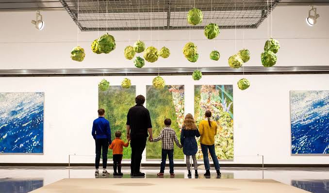 A family of five standing in front of two beautiful, large Gathie Falk paintings at Museum London. A family of five standing in front of two beautiful, large Gathie Falk paintings at Museum London.