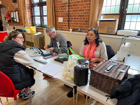 People at work fixing peoples’ broken home appliances at a weekend repair cafe