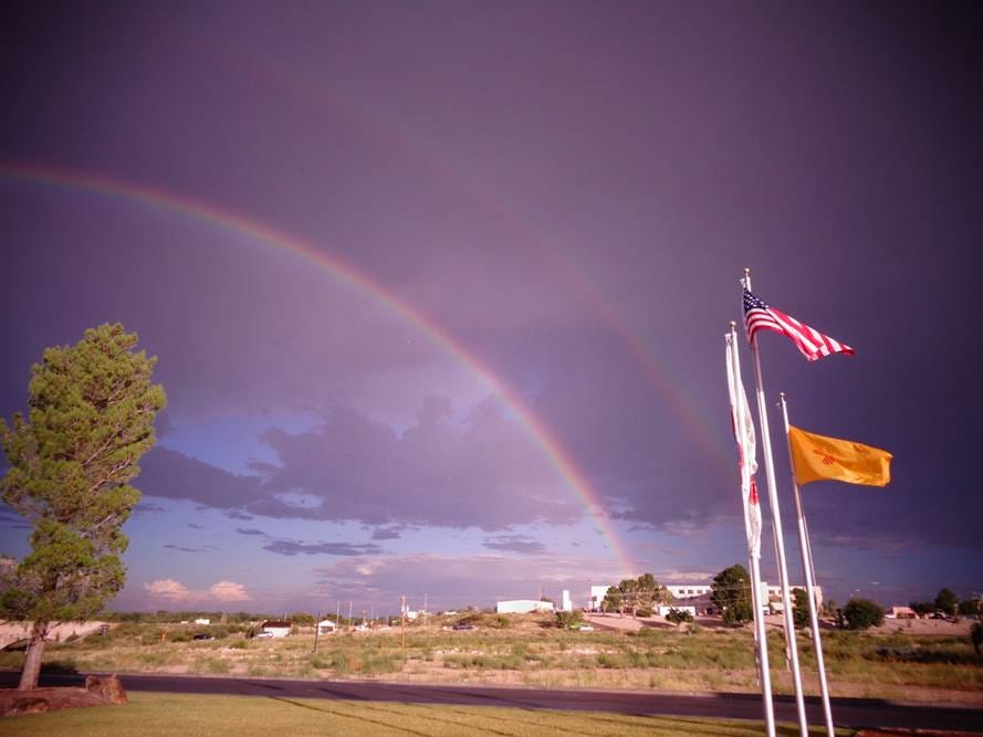 A rainbow over a field with flags

AI-generated content may be incorrect.