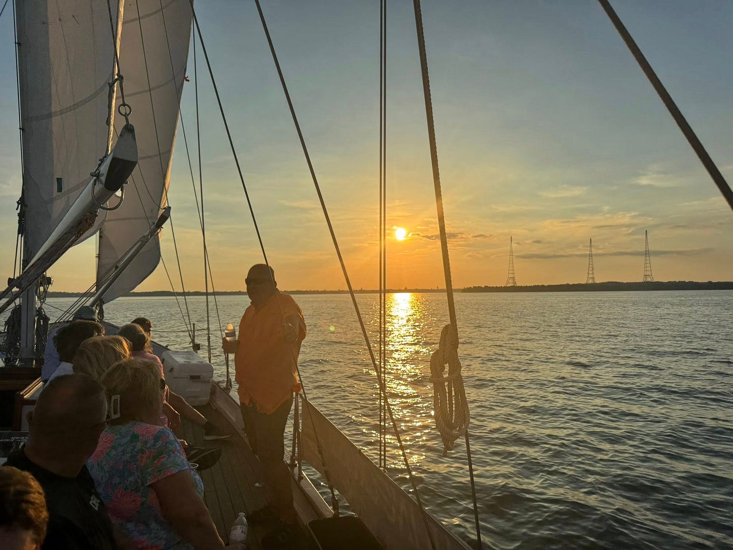 May be an image of 3 people, people boat racing, sail and sailboat
