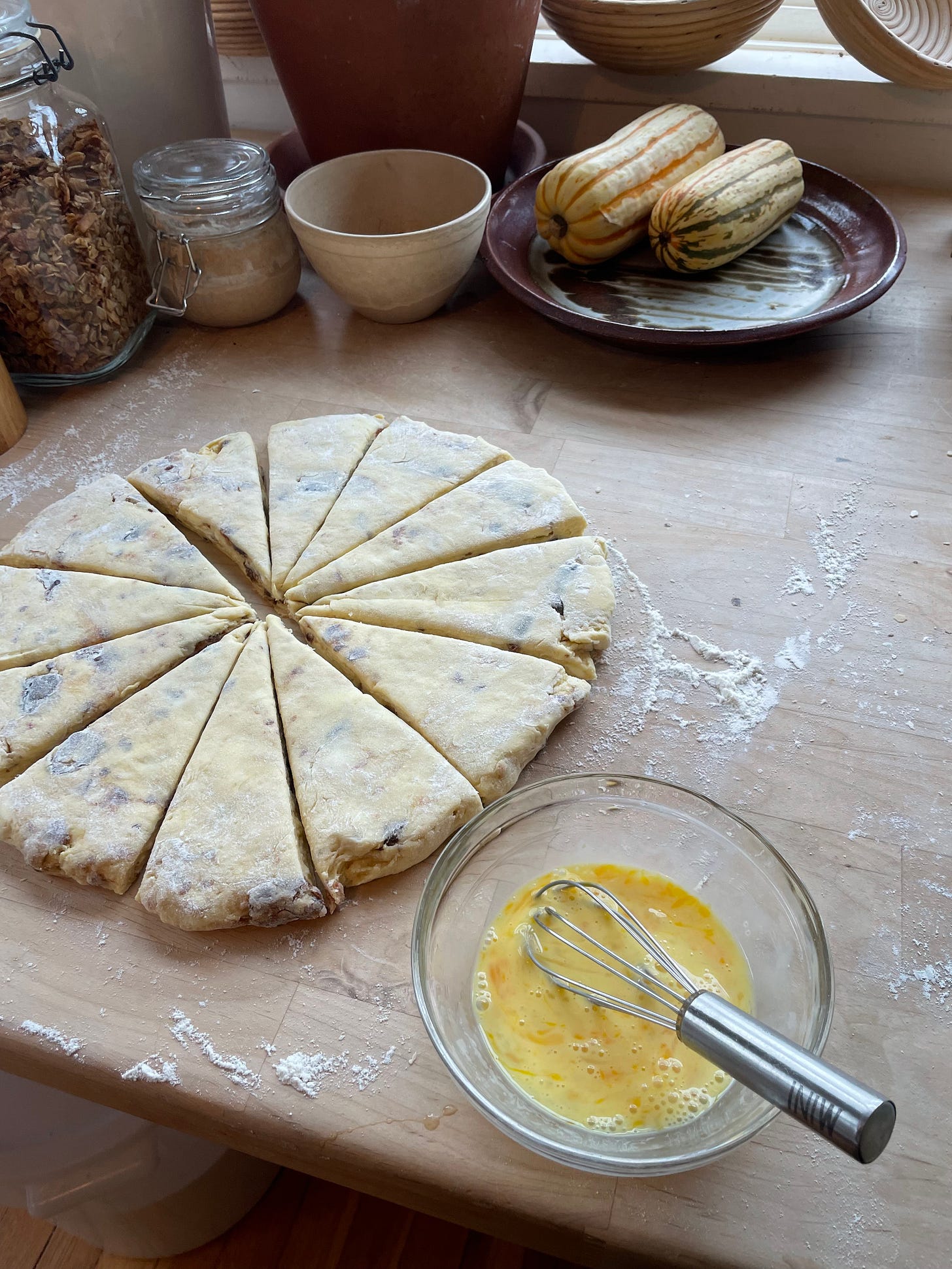 batch of date scone dough on the countertop, with an egg wash beside