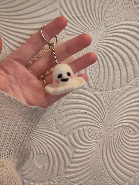 9 pictures of different fiber arts projects including a knit tapestry that says "Protect Trans Youth, a crochet tapestry of a wee ghost, a crochet blanket, a table runner, needle felted keychains, a butterfly cardigan for a little kid, and a blue and white striped cardigan for an adult.