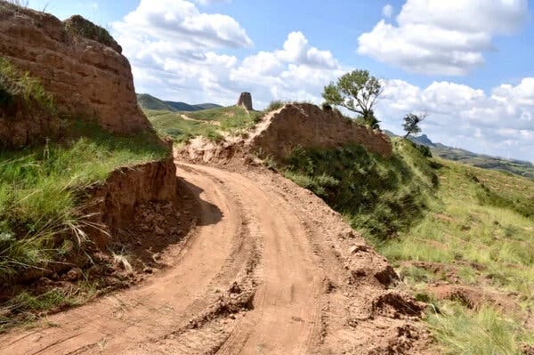 A dirt road passing through a damaged section of the Great Wall of China. A dirt road passing through a damaged section of the Great Wall of China.