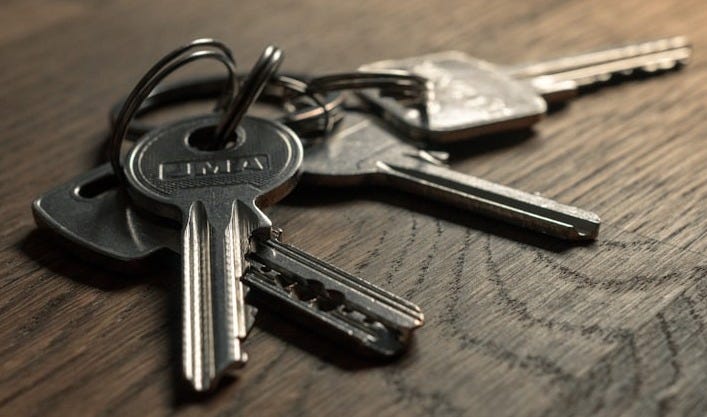 a bunch of keys sitting on top of a wooden table a bunch of keys sitting on top of a wooden table