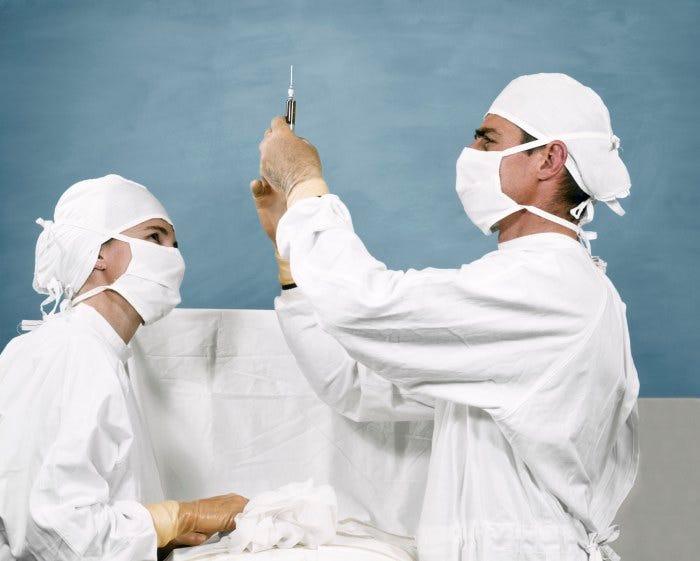 1960s doctor and nurse preparing a syringe.