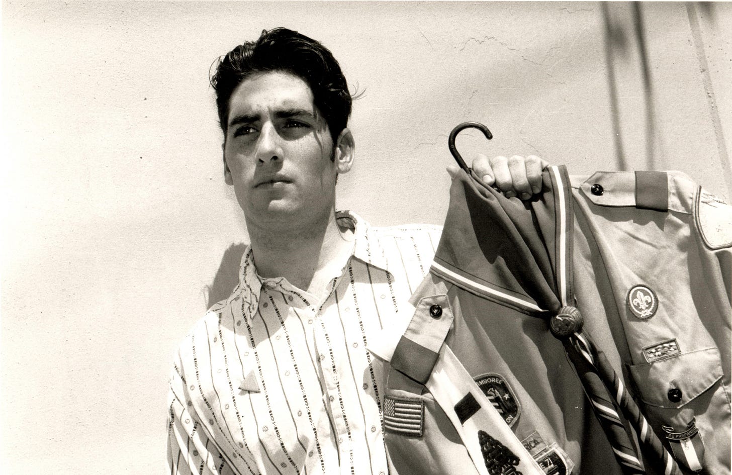 James Dale wearing pink triangle holding scout uniform 