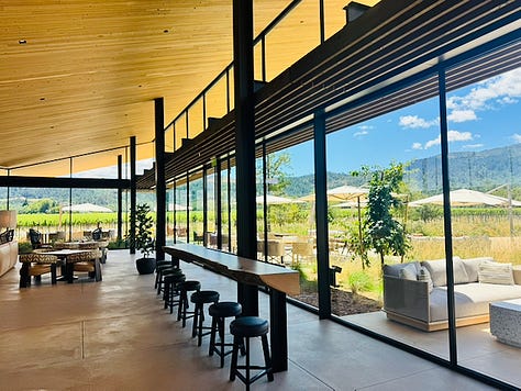 The restored iconic tower at Robert Mondavi Winery against a blue sky, Napa Valley The courtyard garden at Robert Mondavi Winery looking out to the vineyard and Napa Valley mountains The wide interior bar at Robert Mondavi Winery, wood ceiling, floor-to-ceiling windows looking out to the valley The citrus salad course at The Mondavi Table, butter lettuce, castelvetrano olives, pistachios, citrus vinaigrette Robert Mondavi Winery stone entrance sign with wildflowers, Oakville, Napa Valley Handmade ricotta capelletti with Genovese pesto, English peas, and pecorino romano at The Mondavi Table The Napa River viewed from the third floor patio at River Terrace Inn, downtown Napa The vaulted stone cave at Inglenook, crystal chandelier over a long wooden table, Rutherford, Napa Valley The grand staircase at Inglenook château, red carpet and stained glass, unchanged since 1879