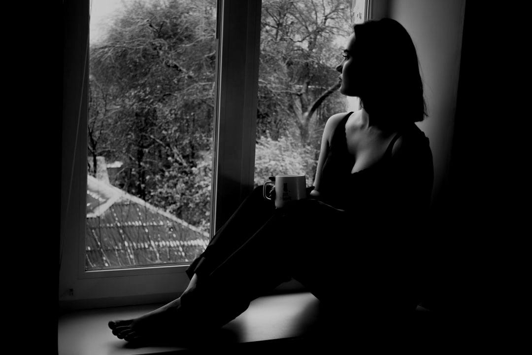 woman in black tank top sitting on window