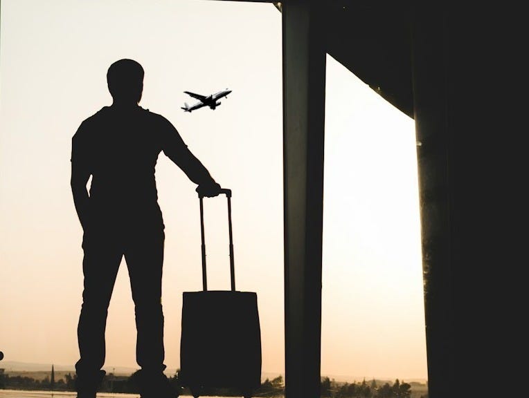 silhouette of man holding luggage inside airport