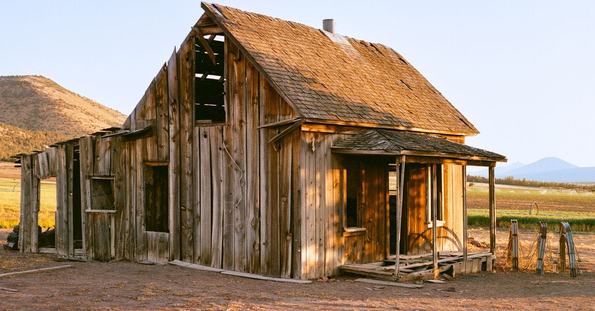 Photo: Jason Renfrow Photography / Pexels A rustic abandoned cabin sits in a sunlit desert landscape, capturing a timeless rural charm.