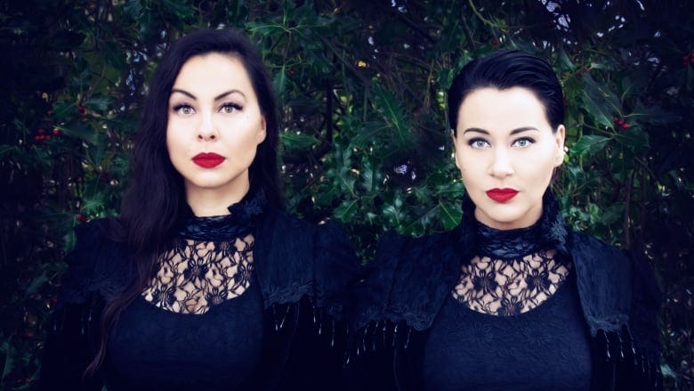 Sisters Tiffany Ayalik and Inuksuk McKay of the electronic, throat singing duo PIQSIQ stand in front of shrubbery.
