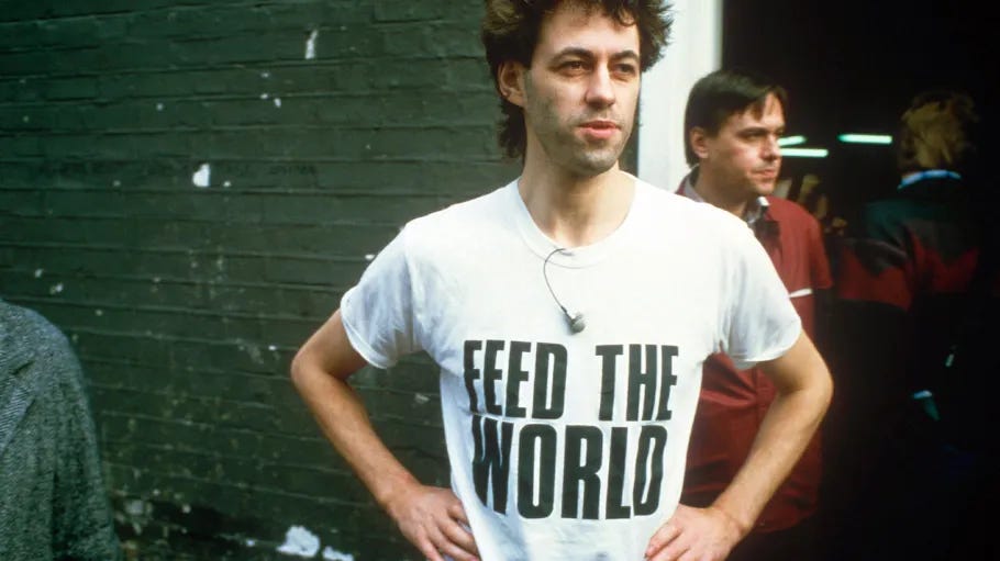 Bob Geldof wearing a white t-shirt that reads "FEED THE WORLD". Bob Geldof wearing a white t-shirt that reads "FEED THE WORLD".