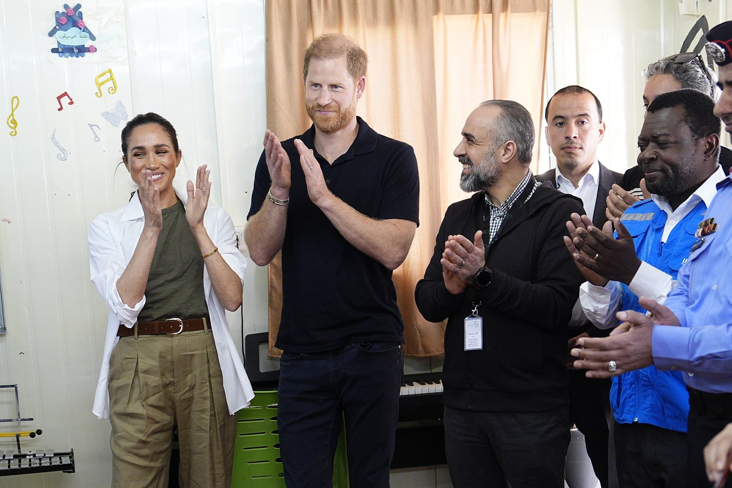 Meghan and Harry clapping standing together Meghan and Harry clapping standing together