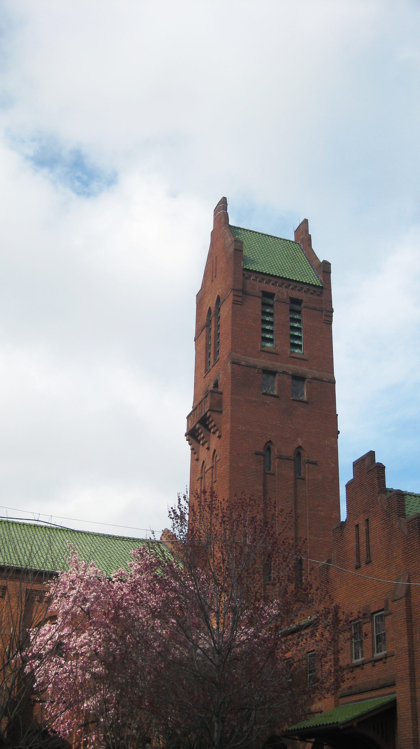 A digicam photograph of a brick building in downtown Baltimore, beset by spring trees.