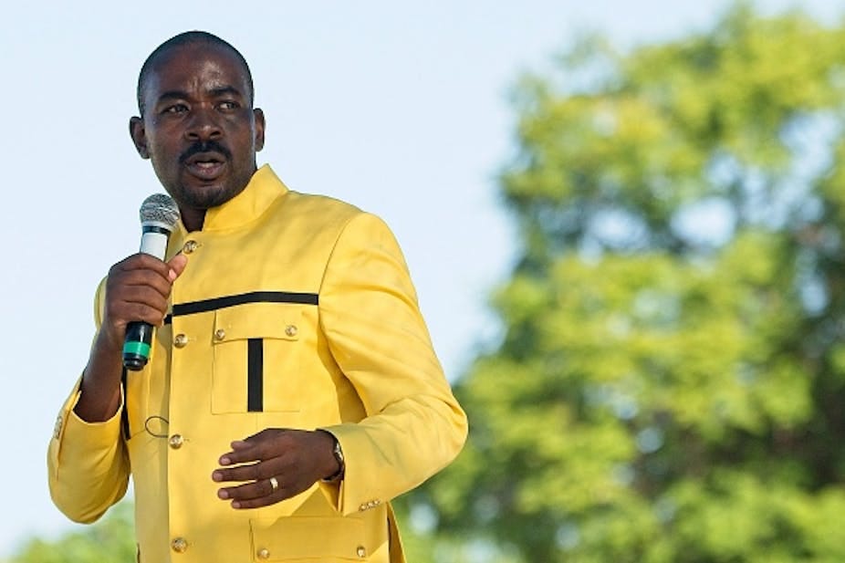 A man speaks into a microphone in his right hand. A man speaks into a microphone in his right hand.