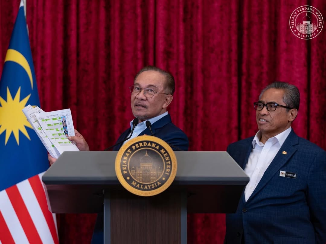 Malaysia Prime Minister Anwar Ibrahim displays a list of new Cabinet appointments after announcing a major reshuffle in December 2025, signaling political recalibration ahead of elections.