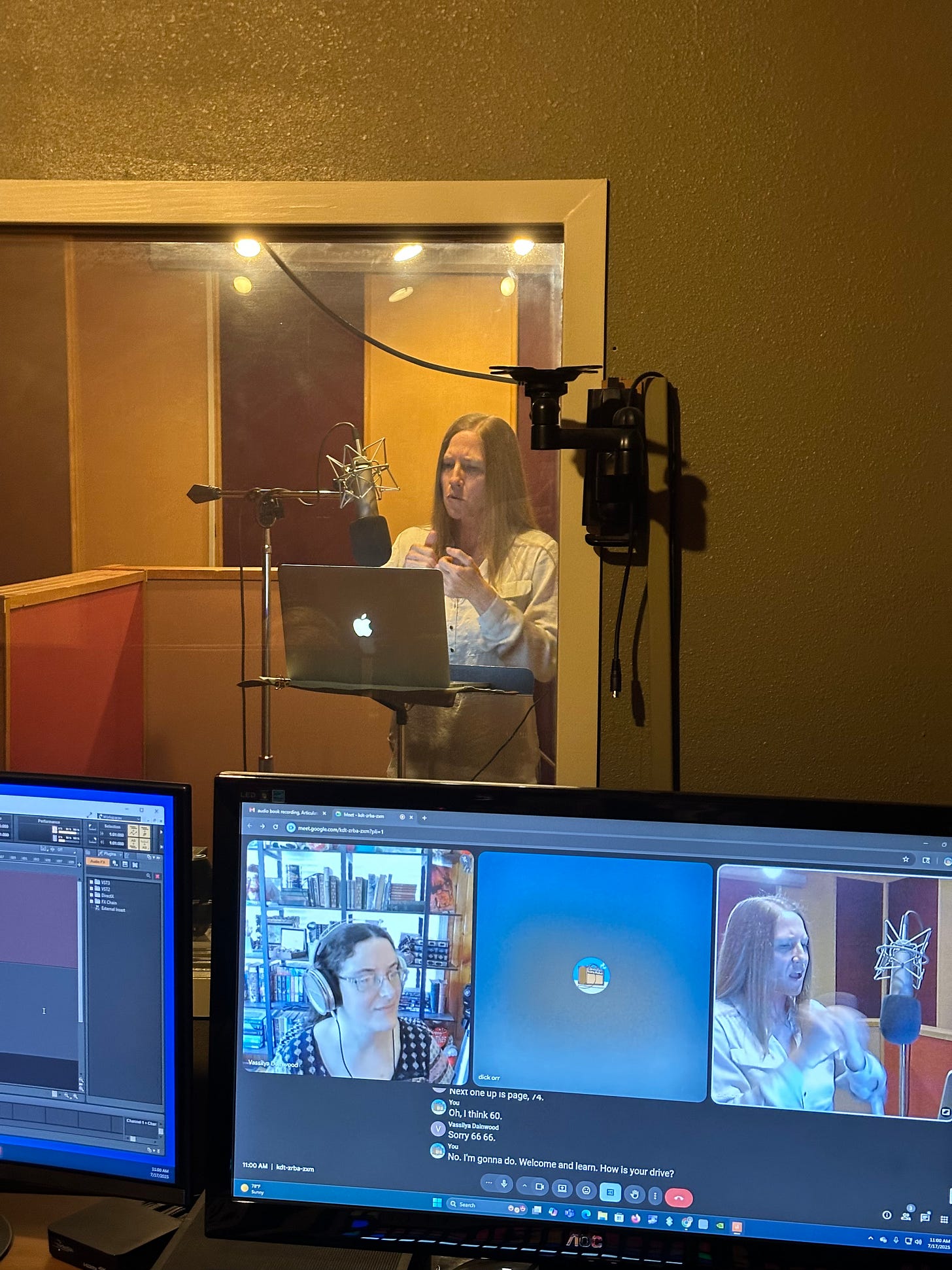 Shot of me signing the ASL portions of the book in the recording studio. I'm standing beside a microphone with my face focused. The sound engineer's computer screen (with Google Meet open) is in the foreground.