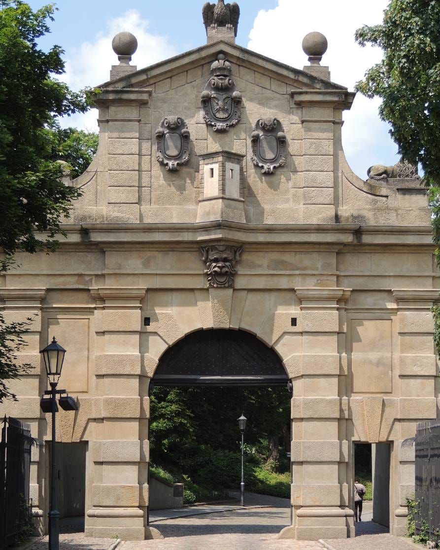 A stone archway with a gate

AI-generated content may be incorrect.