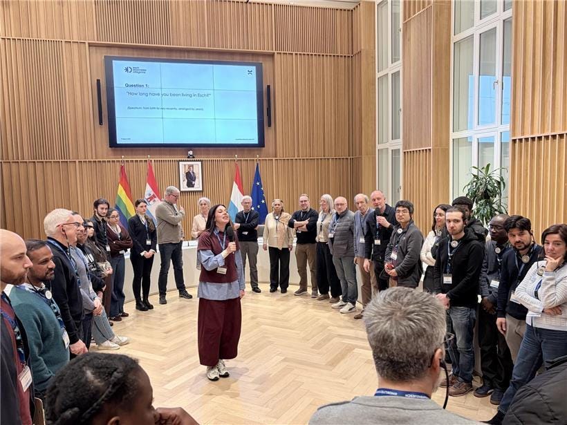 Moderator Liz Thielen from Snakke & Co. leads an engaging session of the Assemblée citoyenne in a modern conference environment.