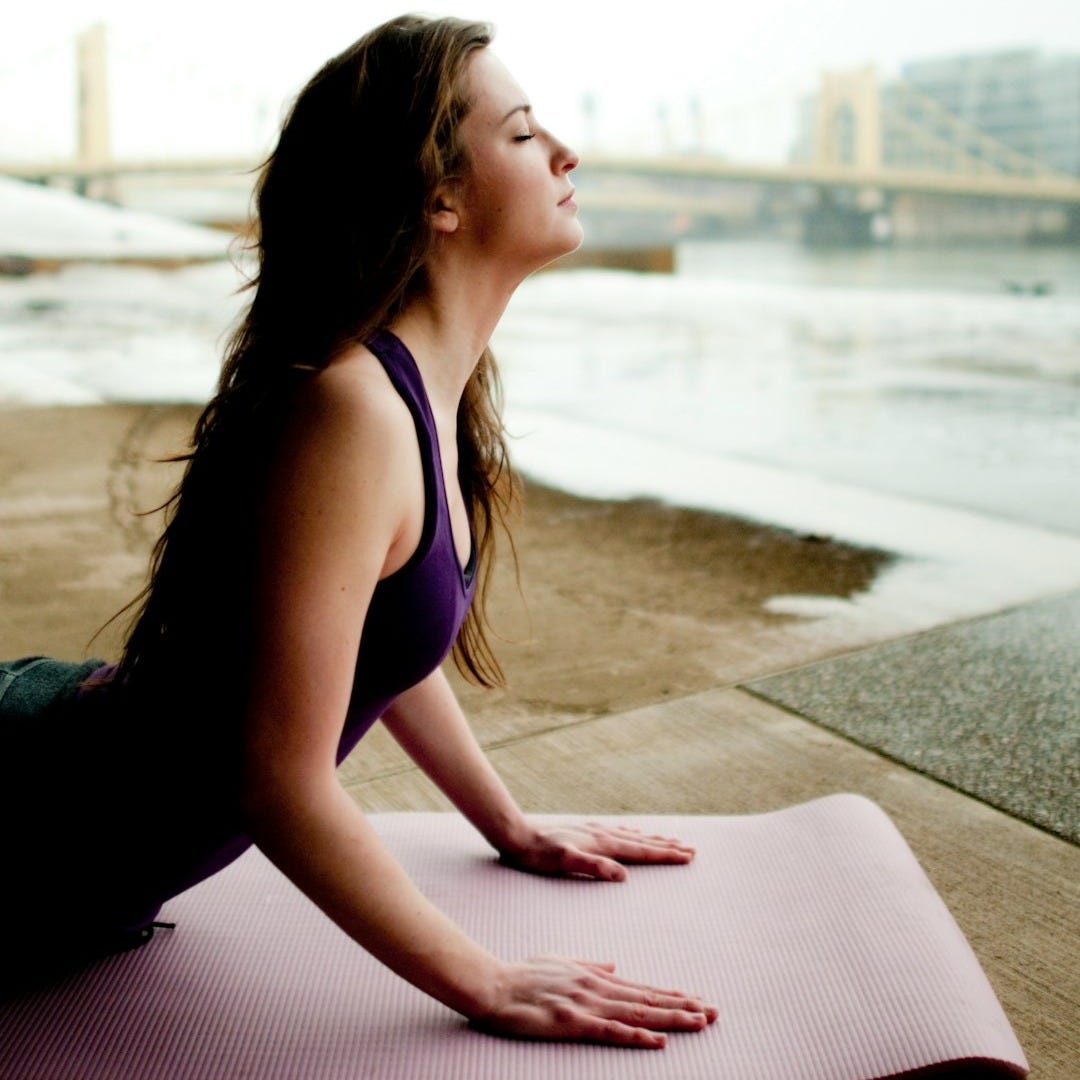 woman in black tank top sitting on concrete floor during daytime woman in black tank top sitting on concrete floor during daytime