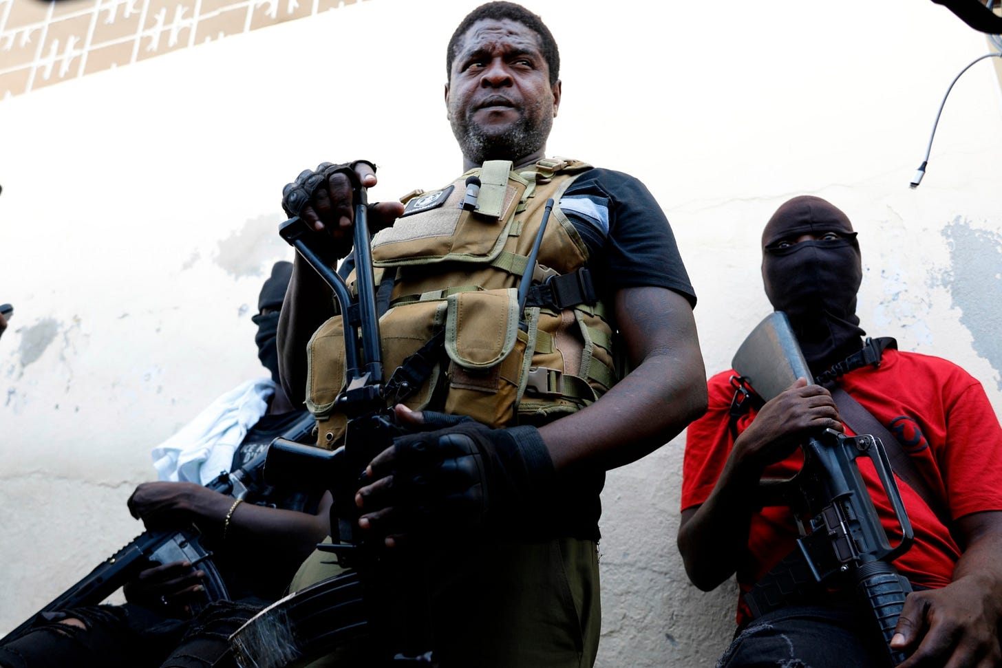 Barbecue, the leader of the "G9 and Family" gang, stands with his fellow gang members after speaking to journalists in the Delmas 6 neighborhood of Port-au-Prince in Port-au-Prince, Haiti, Tuesday, March 5, 2024. (AP Photo/Odelyn Joseph)