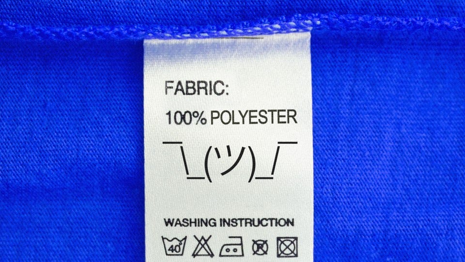 An illustration of a clothing label that says "100% polyester" above the shrug emoticon. An illustration of a clothing label that says "100% polyester" above the shrug emoticon.