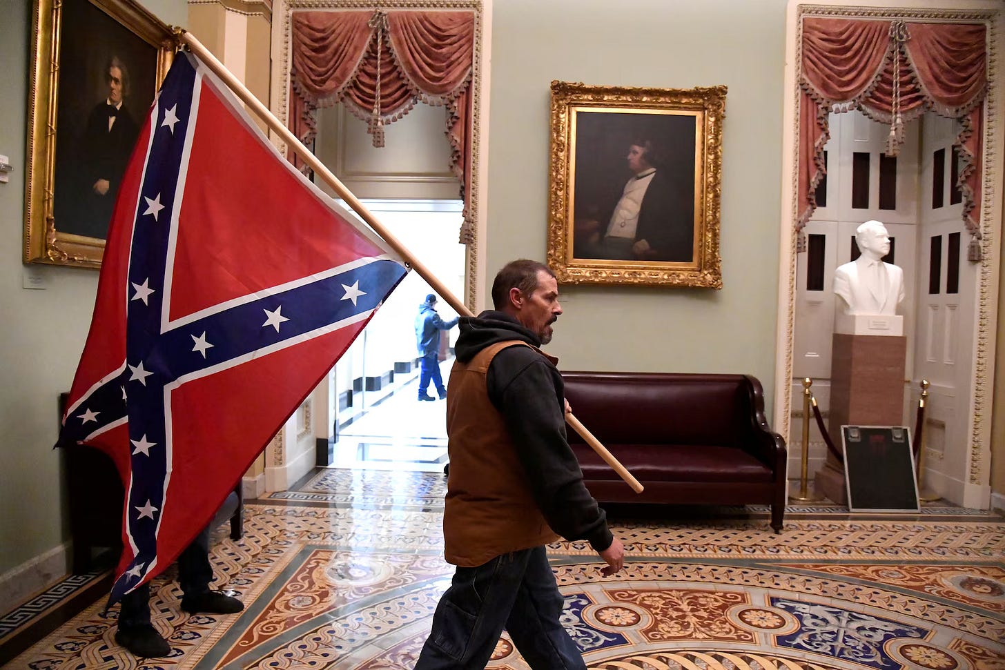 A supporter of President Trump carries a Confederate battle flag on the second floor of the Capitol near the entrance to the Senate REUTERS/Mike Theiler