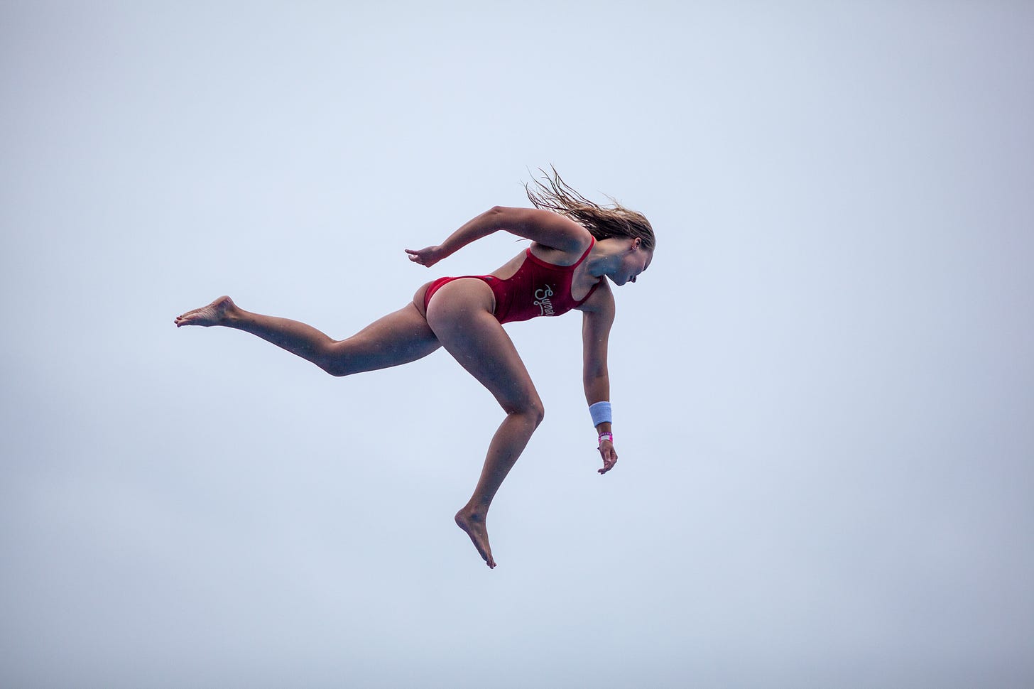 Female Døds Diving League athlete performs an aerial jump during a competition.
