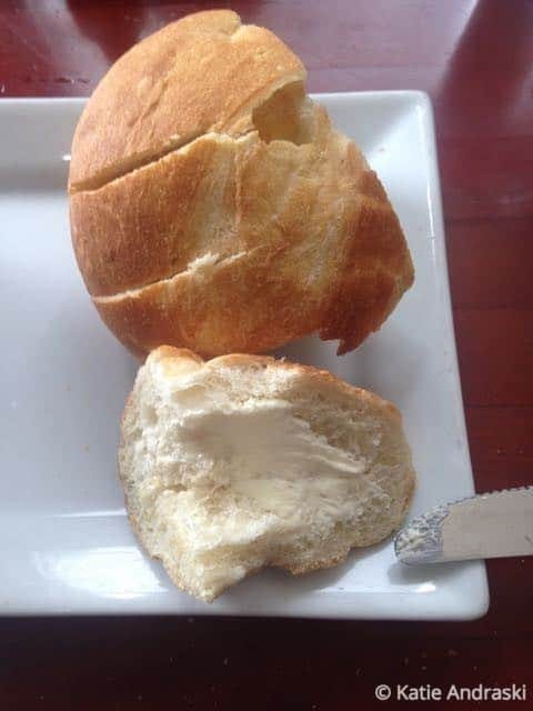 Bread roll with butter on plate.