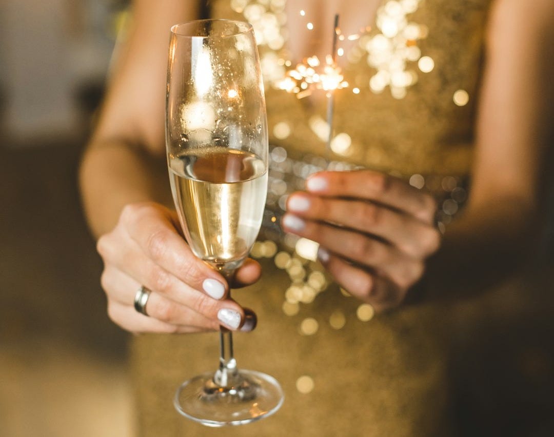 woman in white dress holding clear wine glass woman in white dress holding clear wine glass